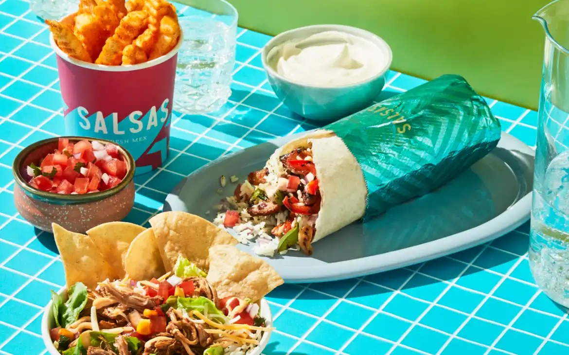 A Salsas spread of a burrito, bowl, fries, chips and salsa